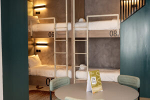 Sesaya Poshtel bunk room with numbered pods and lounge table