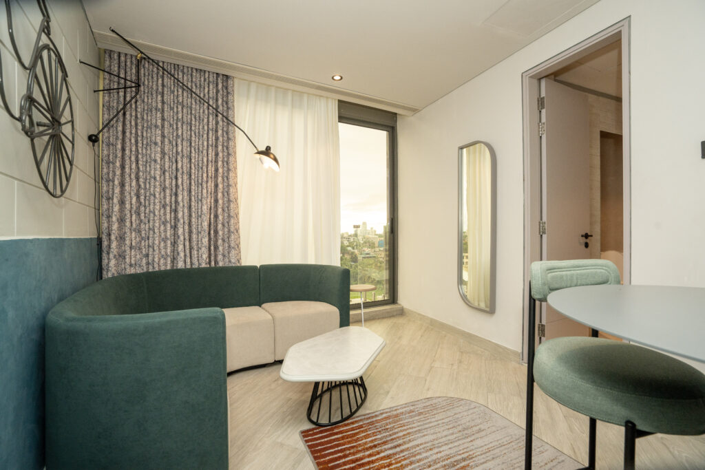 Sesaya Poshtel private room with teal headboard and mirrored wall