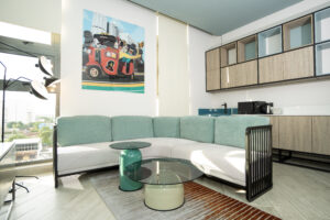 Sesaya Poshtel lounge with teal sofa and city-view window
